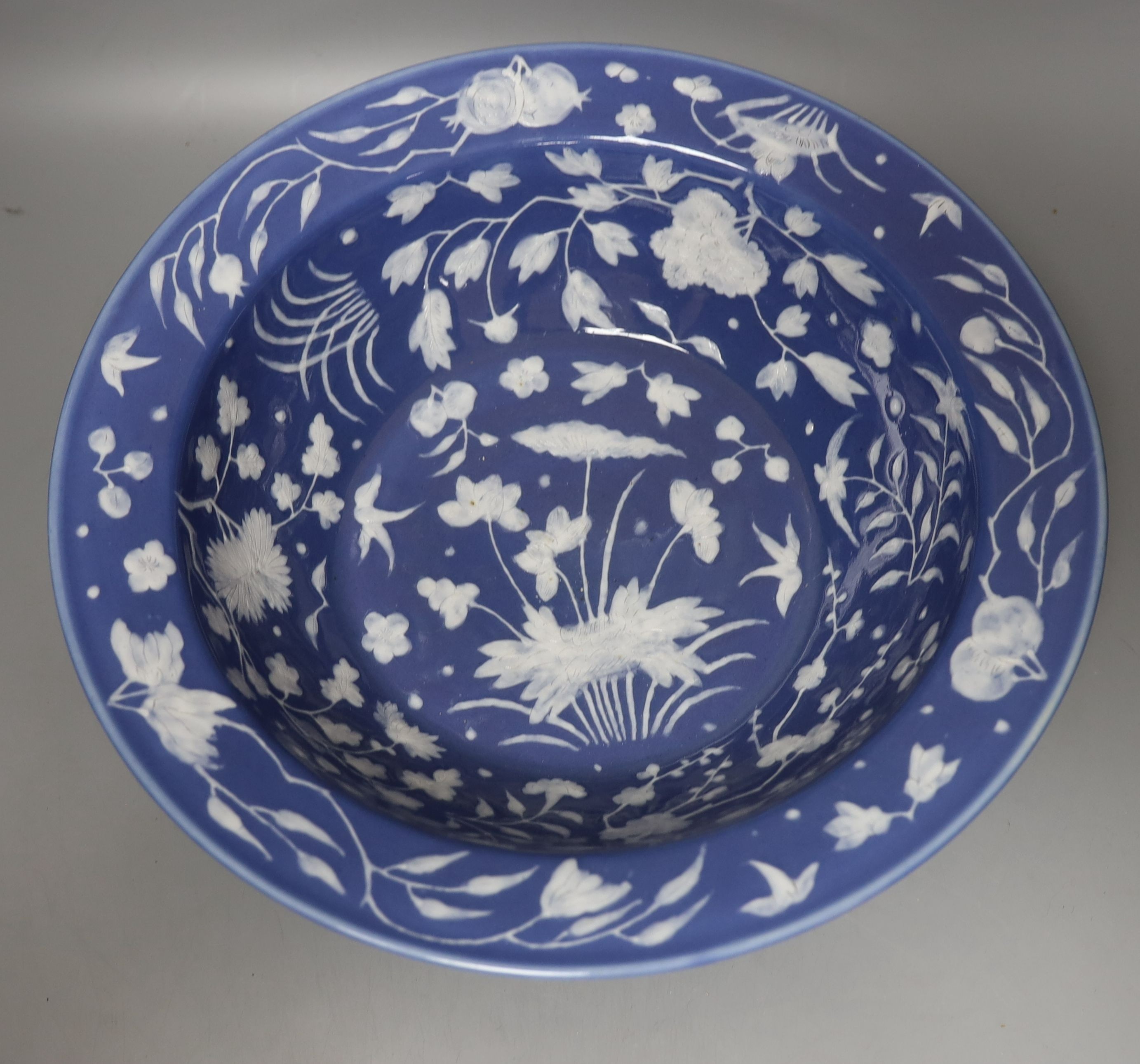 A Chinese export slip decorated blue ground basin, c.1830 - 40cm diameter